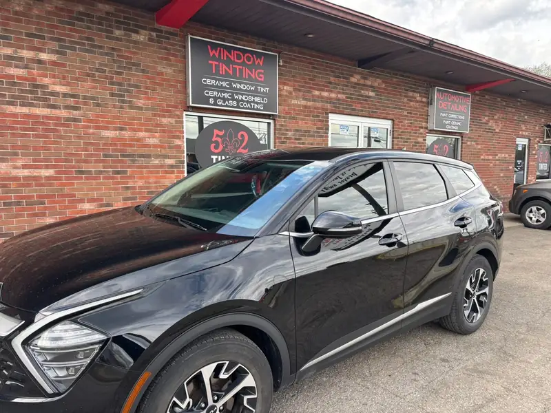 Black Kia Sportage with fresh window tint in front of 502 Tinted