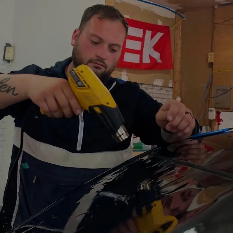 Shane Crosier, owner of 502 Tinted, heat-shrinking window film in the shop