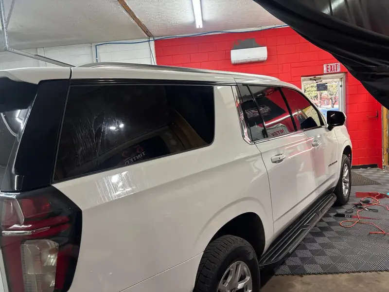 White Chevrolet Suburban with tinted rear glass in the red 502 Tinted bay